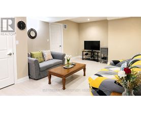A living room with a grey couch, a wooden coffee table, and a yellow and grey striped sofa.