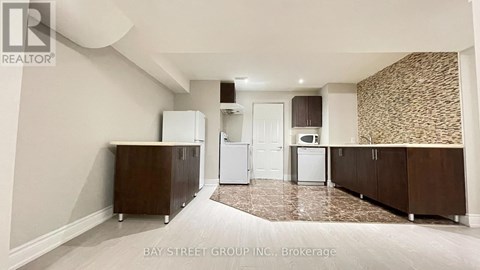 A kitchen with white appliances and brown cabinets.