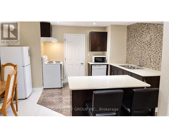 A kitchen with a white fridge, microwave, and oven.