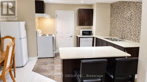 A kitchen with a white fridge, microwave, and oven.