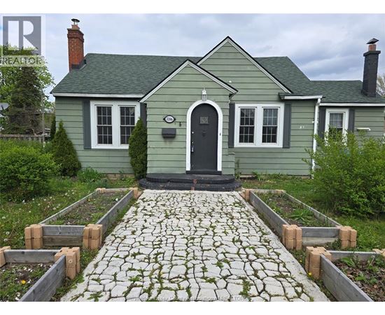 A green house with a black door and windows.