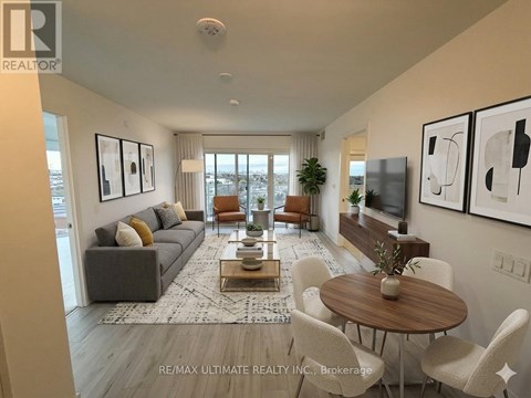 A living room with a grey couch, a coffee table, and a dining table with chairs.