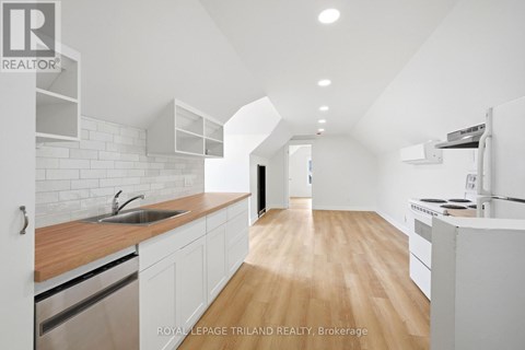 A modern kitchen with white cabinets and a wooden countertop.