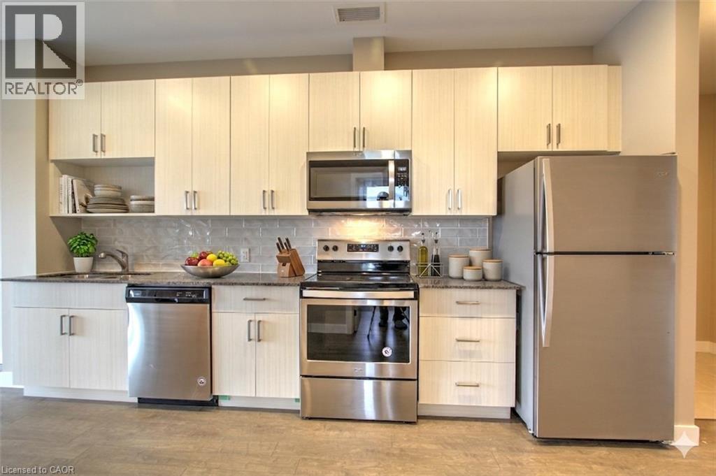 A kitchen with a refrigerator, stove, oven, and microwave.