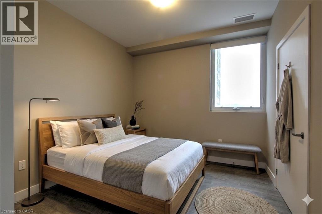 A bedroom with a bed, bench, and window.