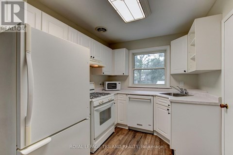 A kitchen with white appliances and cabinets.