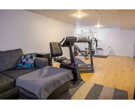 A home gym with a treadmill, exercise bike, and weights.