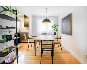 A dining room with a wooden table and chairs.