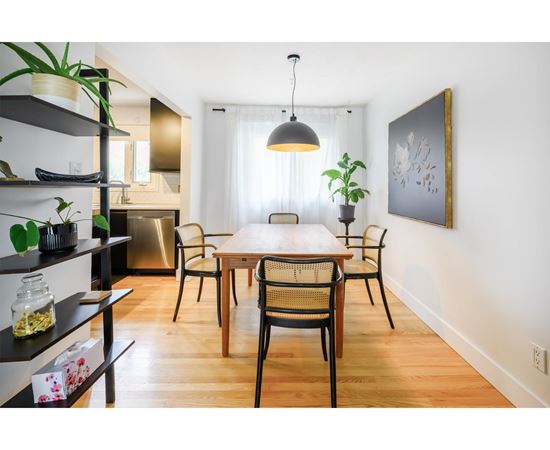 A dining room with a wooden table and chairs.