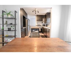A kitchen with a wooden table in the foreground.