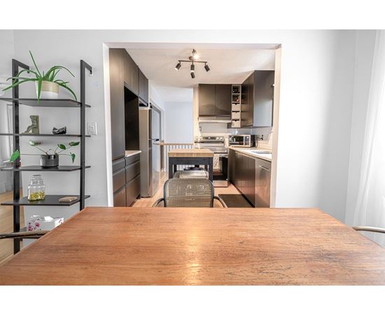 A kitchen with a wooden table in the foreground.