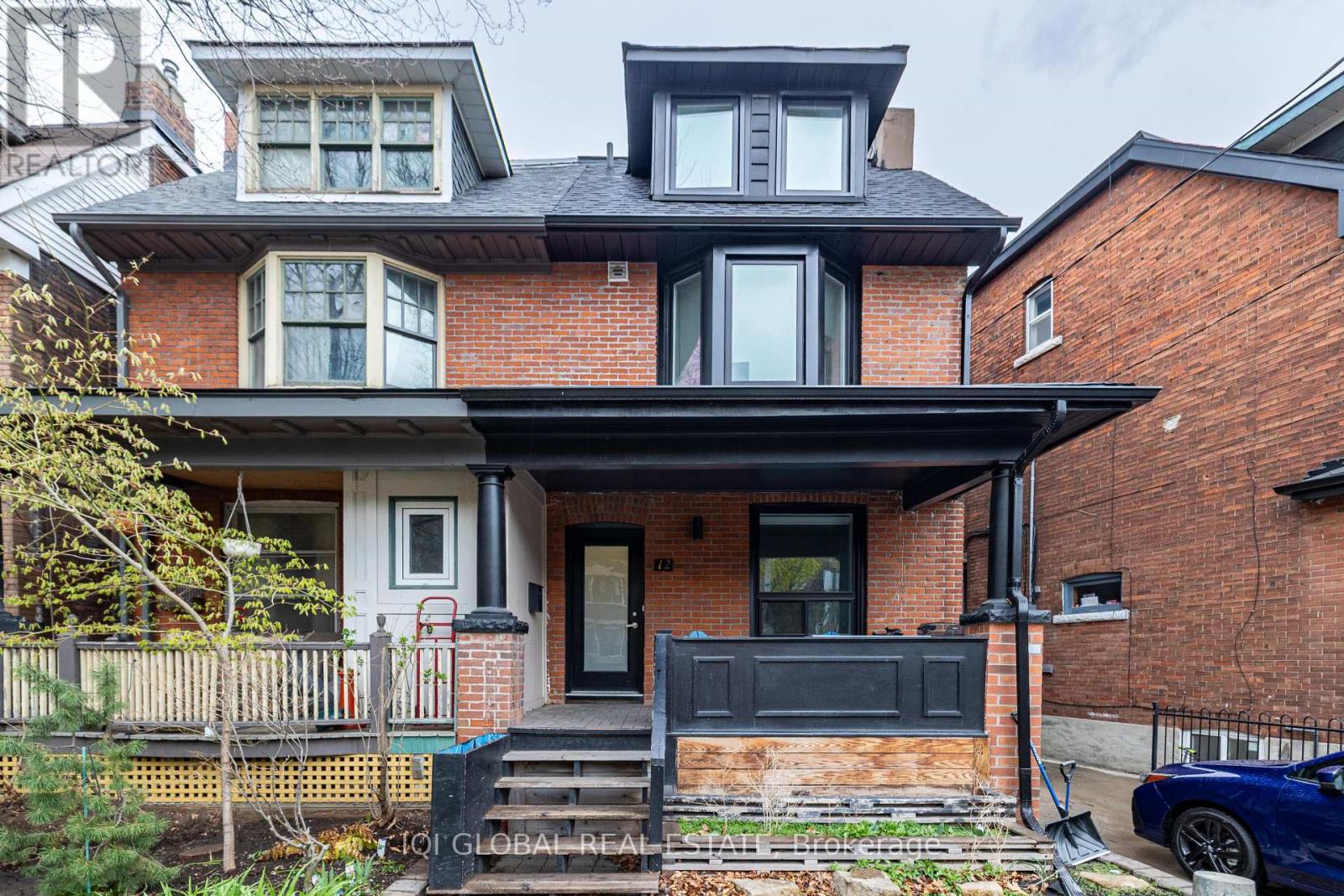 A house with a black front door and a brick facade.