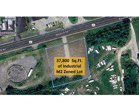 A satellite image shows a blue outlined area with a road and buildings in the background.
