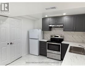 A kitchen with white appliances and black cabinets.