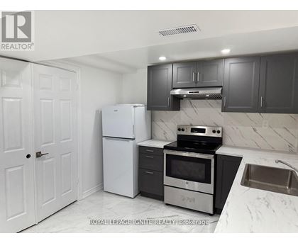 A kitchen with white appliances and black cabinets.