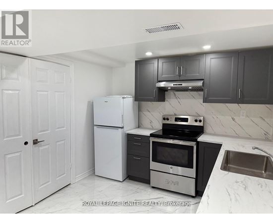 A kitchen with white appliances and black cabinets.
