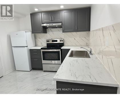 A kitchen with a white refrigerator, stove, and sink.