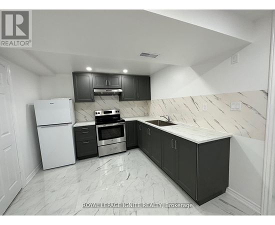 A kitchen with black cabinets and a white refrigerator.