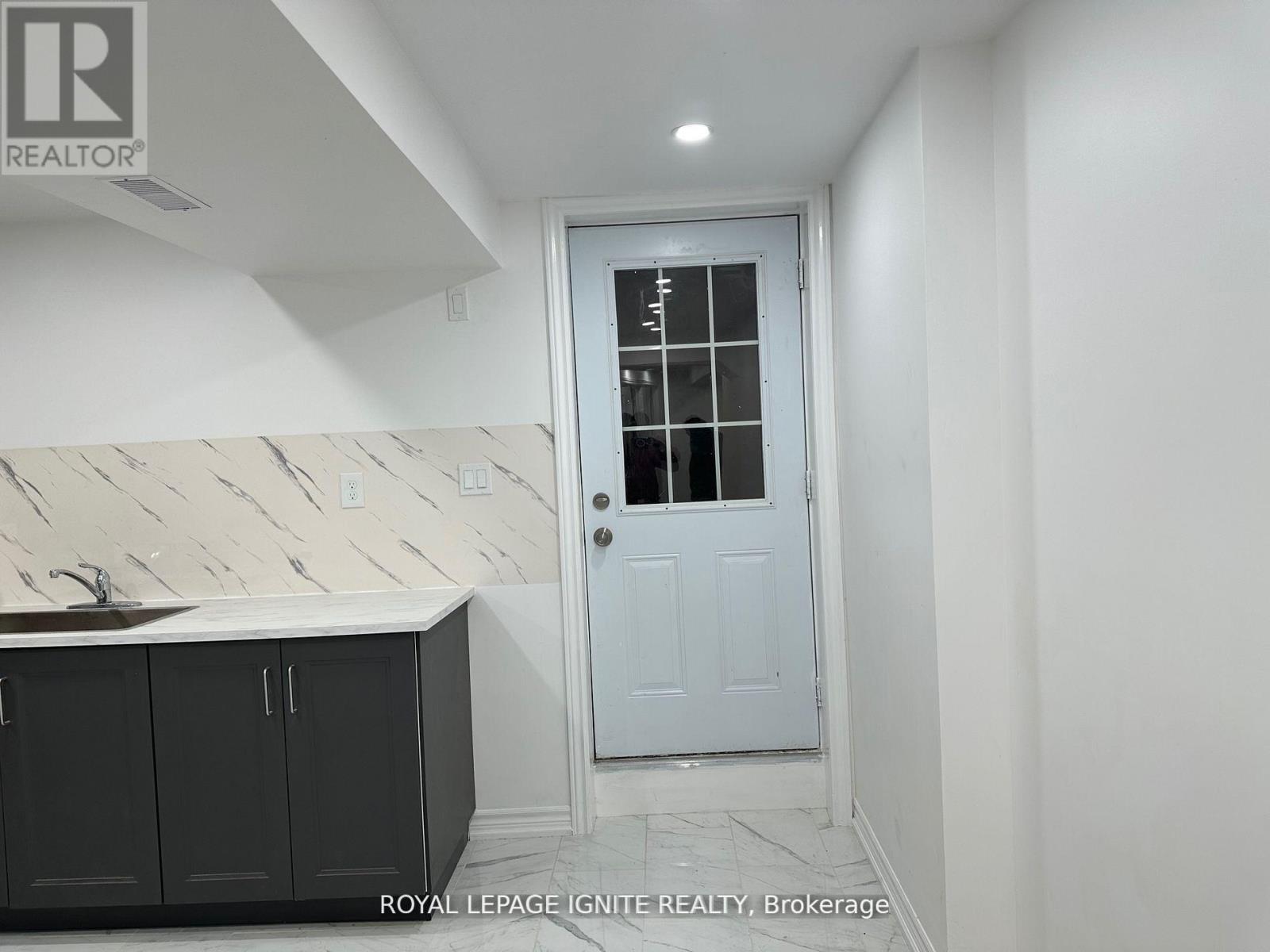 A white door with a glass window is in a room with white walls.