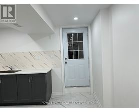 A white door with a glass window is in a room with white walls.