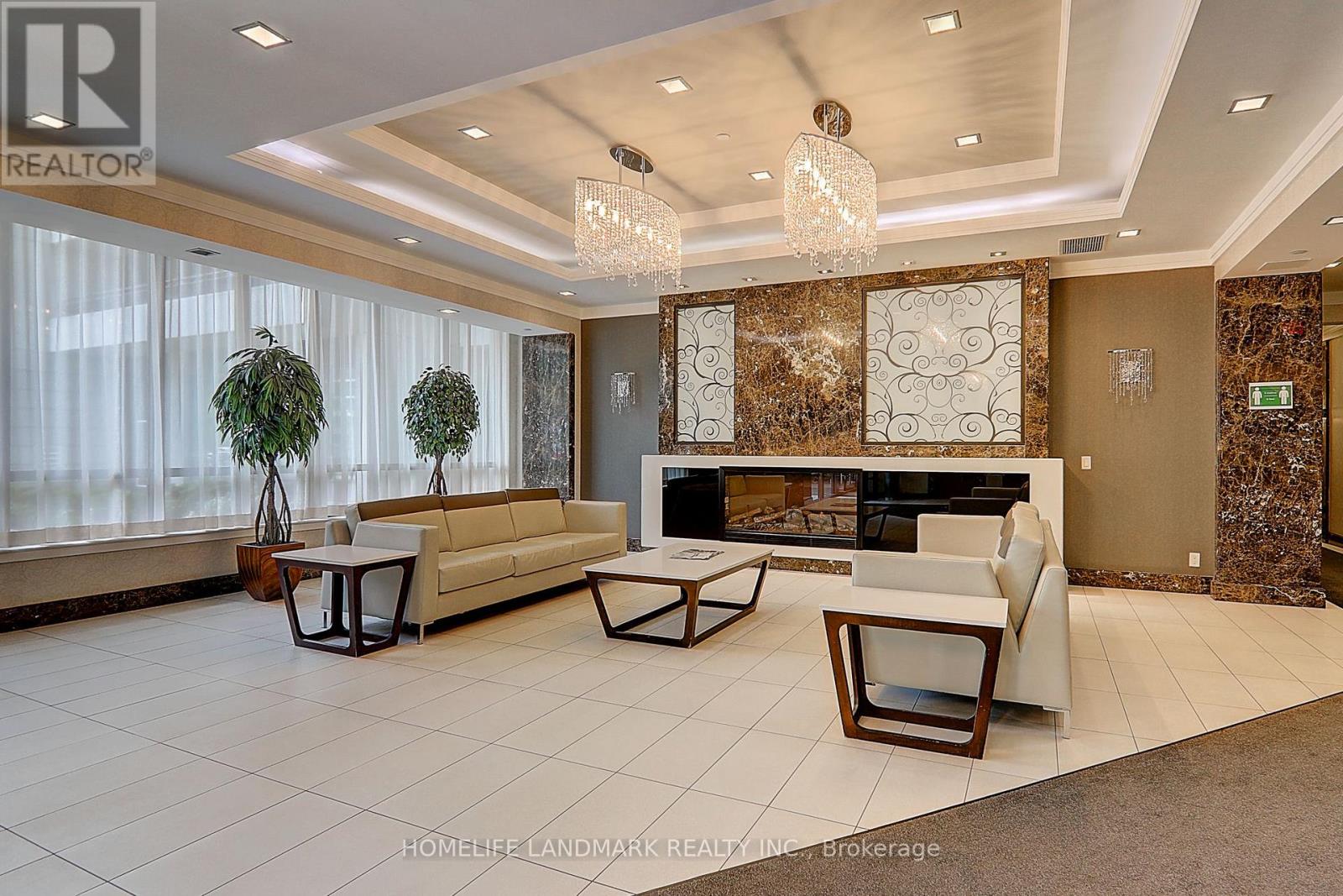 A living room with a white couch, a coffee table, and a fireplace.