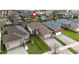 A bird's eye view of a neighborhood with a red pin on a house.