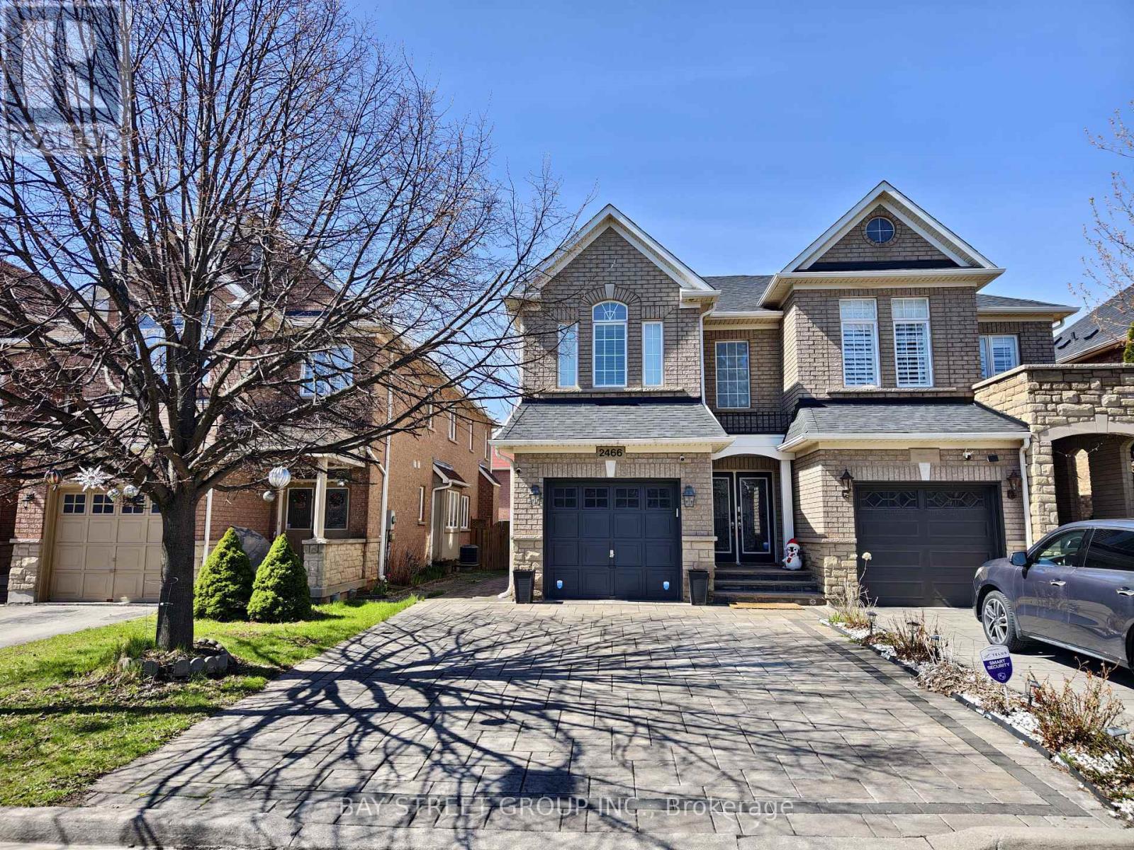 A large, two-story house with a driveway in front.