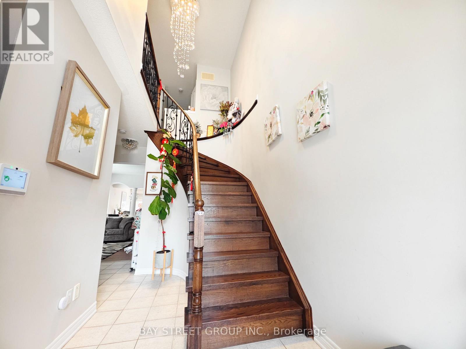 A staircase with a wooden banister and a chandelier hanging from the ceiling.
