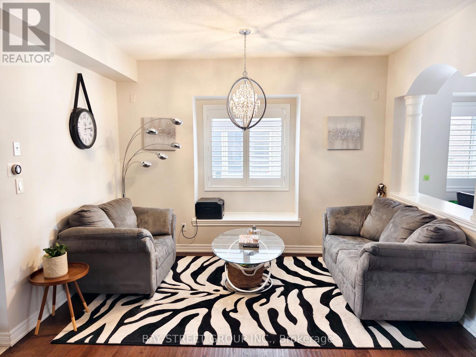 A living room with a zebra rug and grey couches.