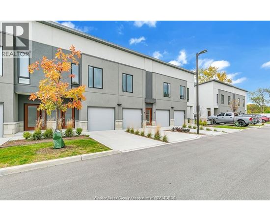 A row of modern townhouses with a clear blue sky above.