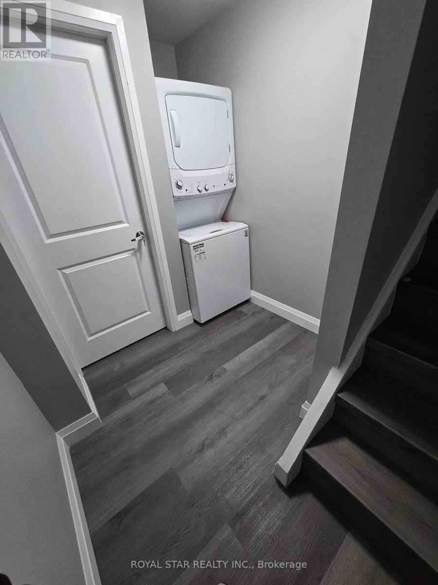 A white toilet and washing machine in a small room.
