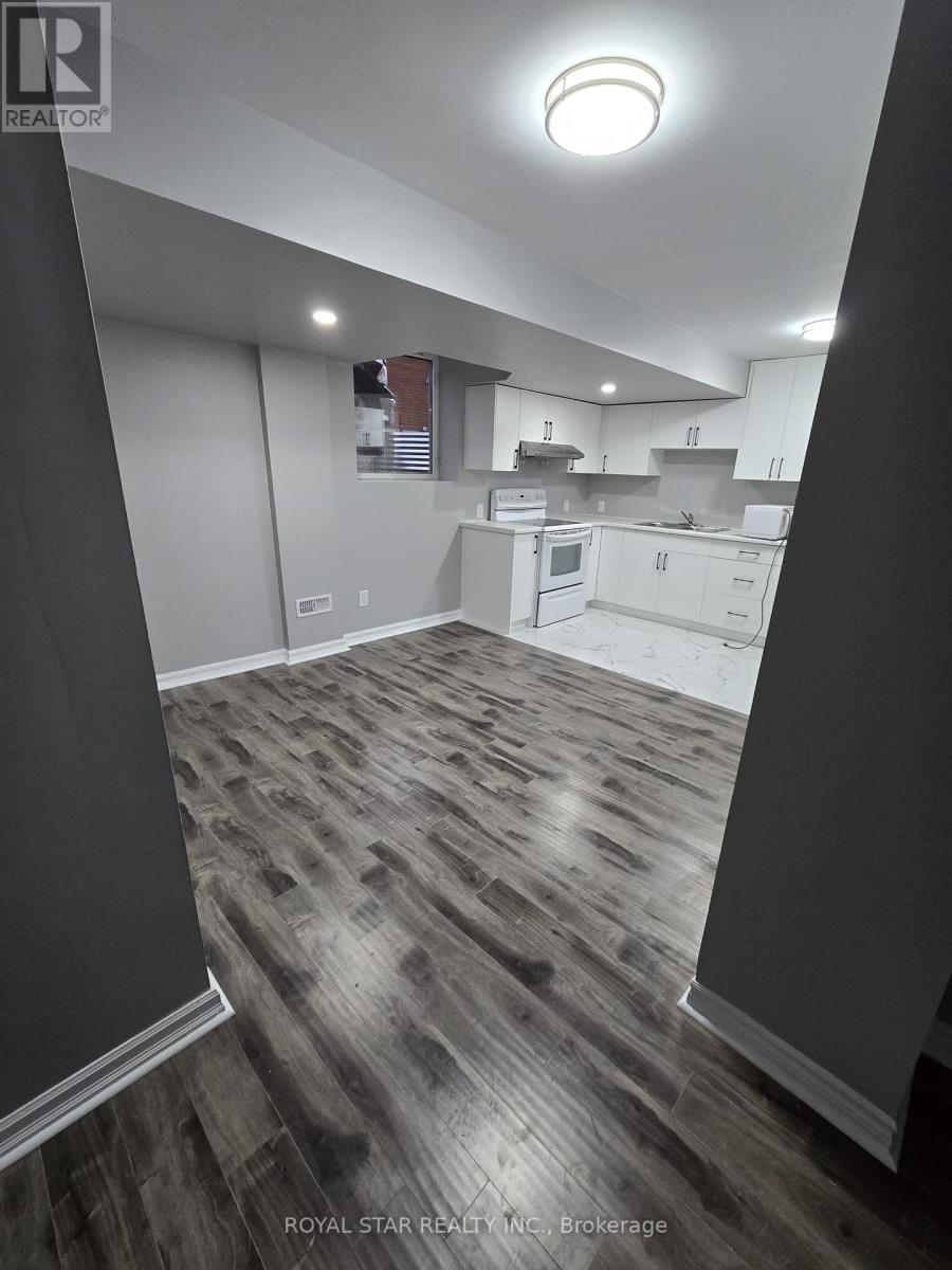 A spacious kitchen with white cabinets and a grey floor.