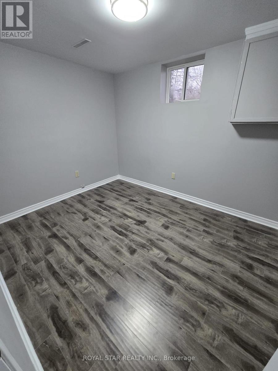 A room with wooden flooring and a window.