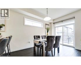 A dining room with a table and chairs.