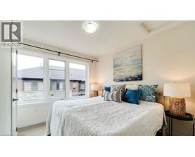 A bedroom with a large bed and a painting on the wall.