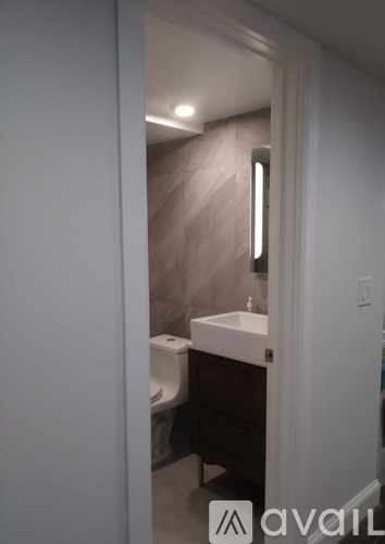 A bathroom with a toilet, sink and mirror.