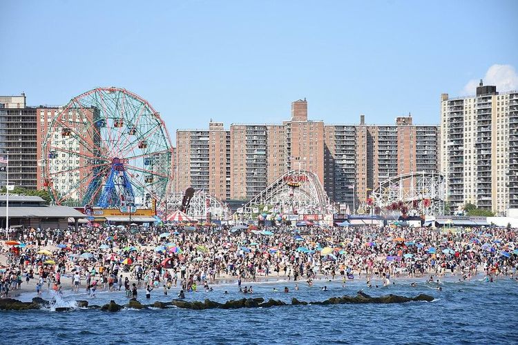 A large amusement park with a Ferris wheel and a crowd of people.