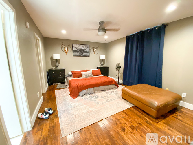 A bedroom with a bed, nightstands, and a rug.