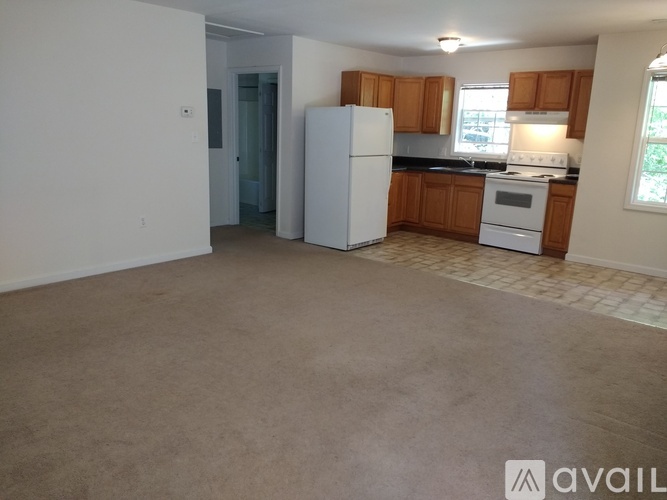 A kitchen with a white refrigerator and wooden cabinets.
