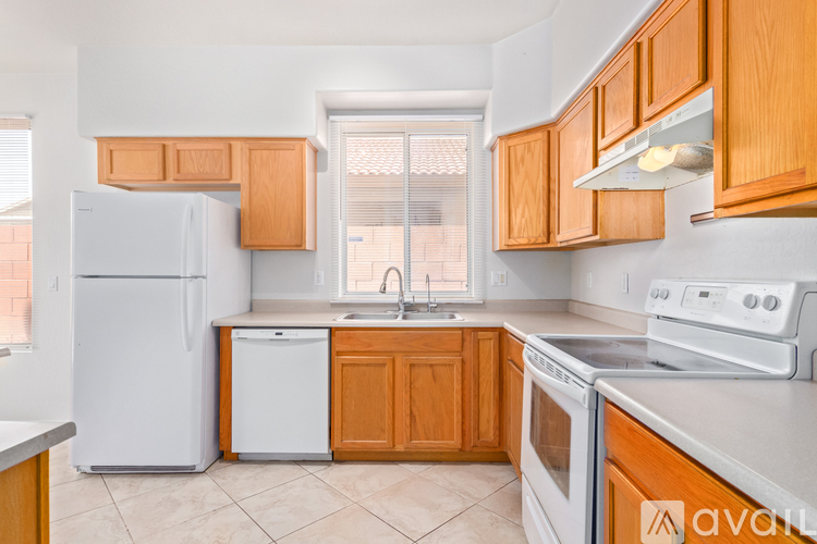 A kitchen with wooden cabinets and white appliances.