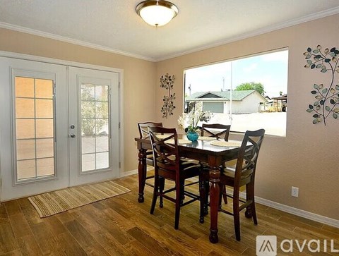 A dining room with a table and chairs and a window.