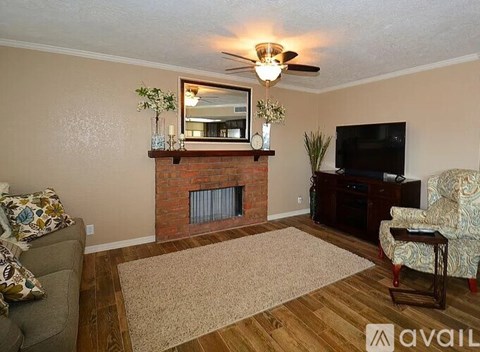 A living room with a fireplace and a flat screen TV.