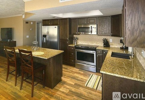 A kitchen with a granite countertop and wooden flooring.