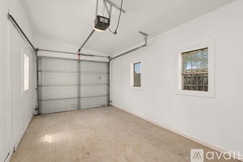 A spacious garage with a white wall and a window.
