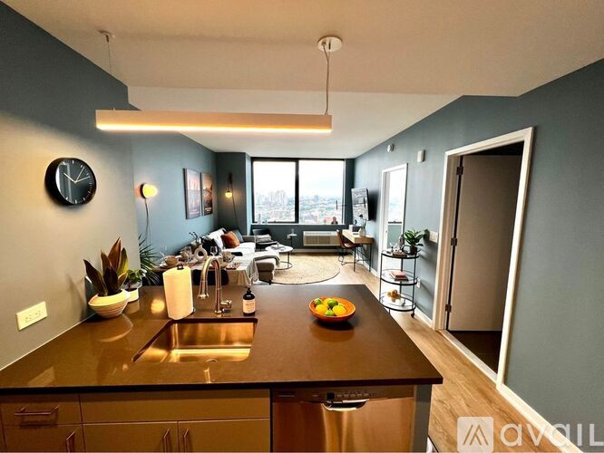 A kitchen with a brown countertop and a clock on the wall.