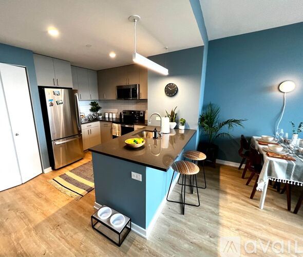 A kitchen with a blue wall and wooden floors.