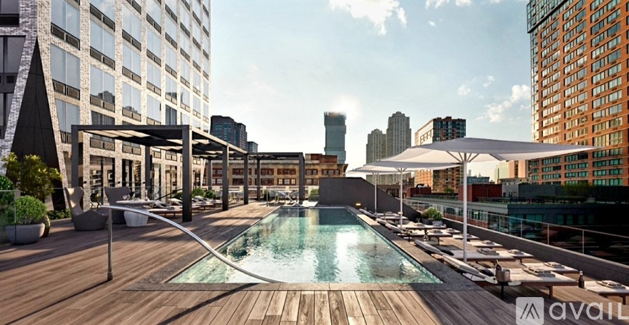A rooftop pool area with a glass barrier and a sun umbrella.