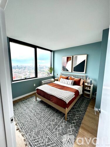 A bedroom with a large bed and a view of the city.