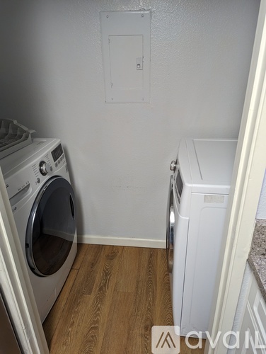 A small laundry room with a washer and dryer.