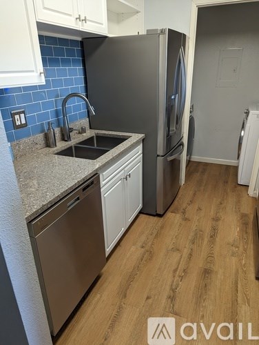 A kitchen with a refrigerator, sink, and dishwasher.
